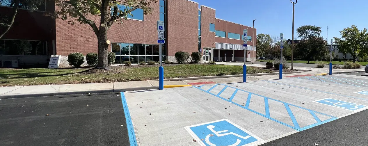 Clearly marked ADA-accessible parking spaces with blue striping in front of a New Jersey commercial building ensure legal compliance