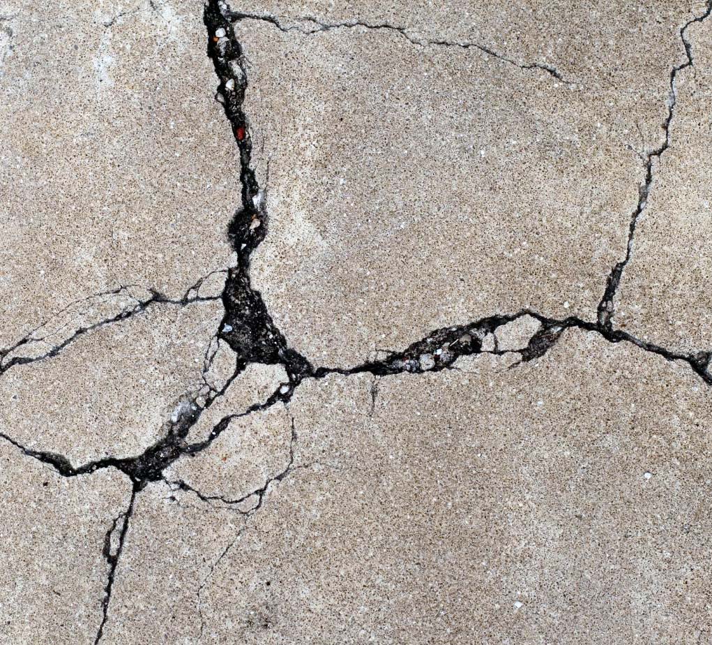 A detailed image showing deep cracks in concrete pavement, used for evaluating damage and determining repair needs
