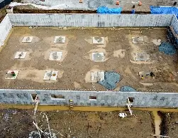 Aerial view of poured concrete foundation walls in place, showcasing the initial phase of a sturdy and well-planned commercial building project