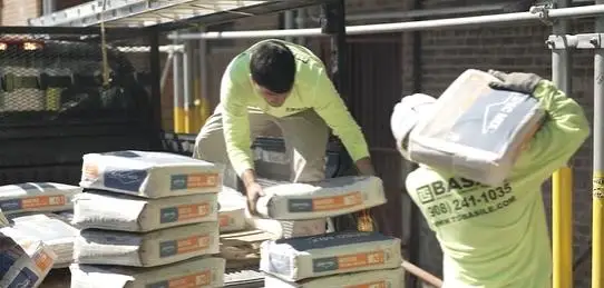 Basile crew members unload and organize masonry materials on-site in Yonkers, NY, preparing for a historic façade restoration