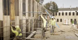 Construction crew installs rebar and formwork for a concrete wall during ground-up warehouse development in Montville, New Jersey