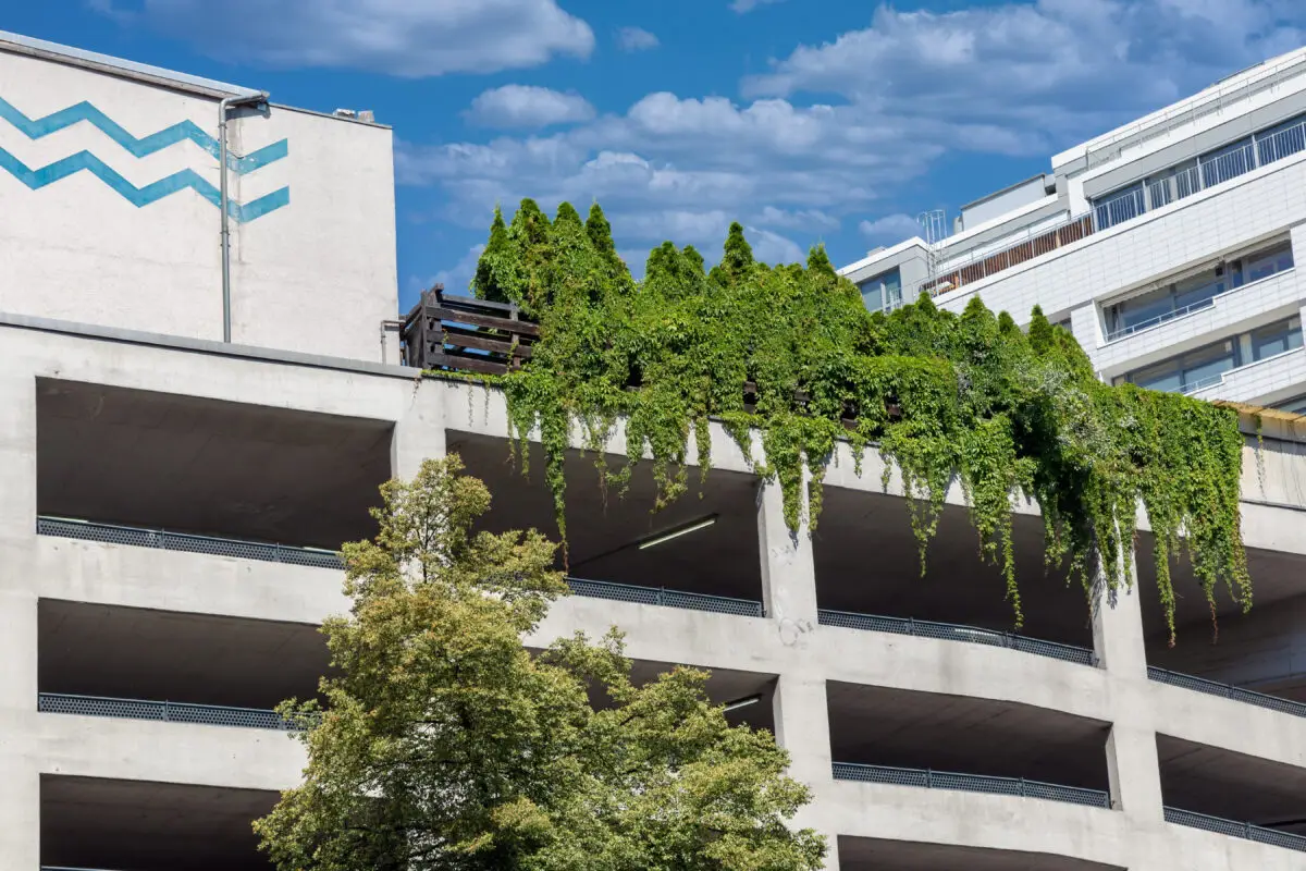 Eco-friendly Berlin parking garage featuring green rooftop garden and concrete structure under blue sky