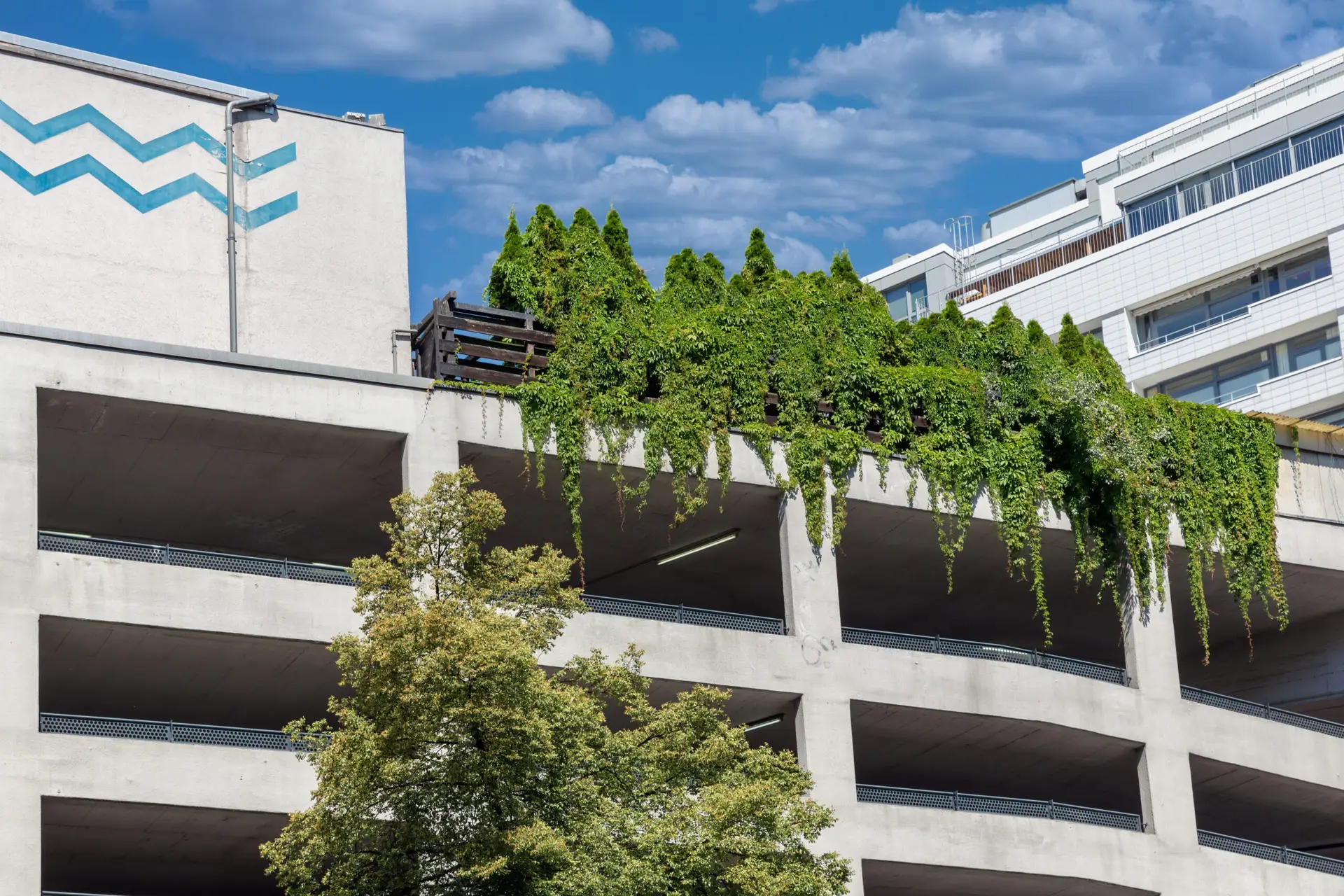 Eco-friendly Berlin parking garage featuring green rooftop garden and concrete structure under blue sky