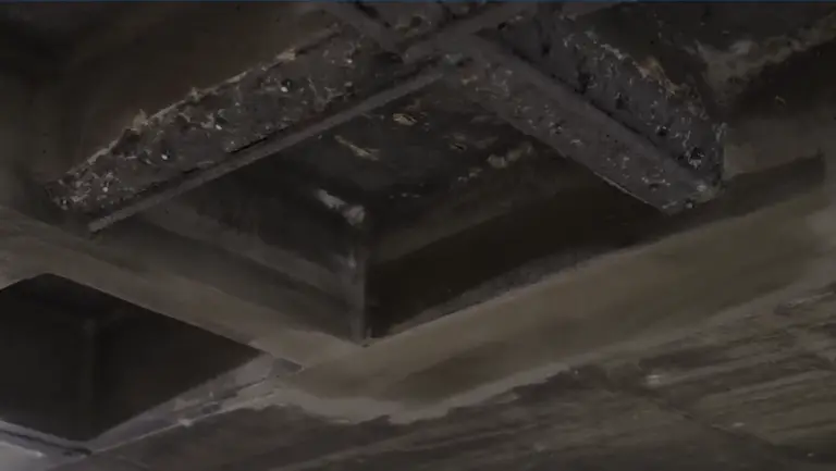 Damaged concrete beam in parking structure indicating need for restoration