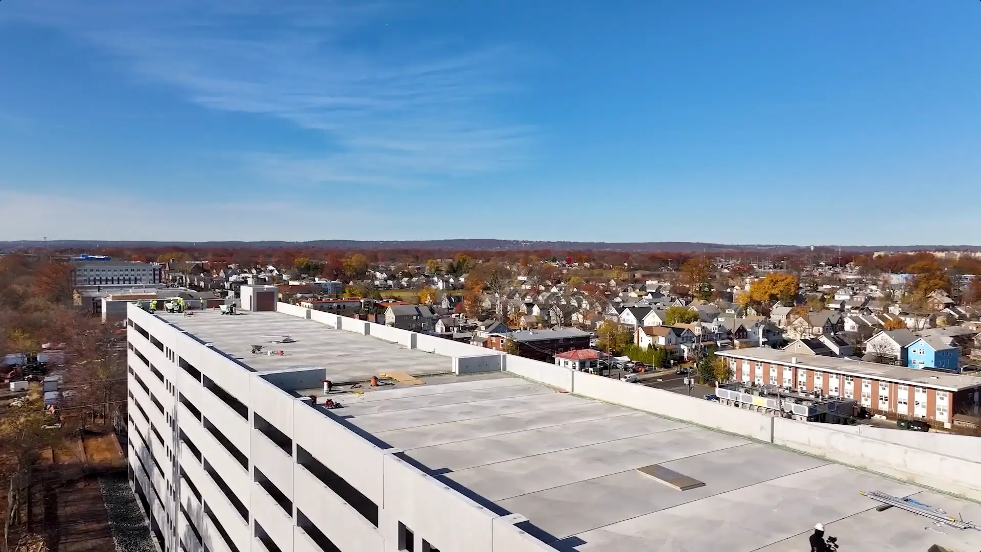 Drone captures workers atop a parking garage during structural restoration, highlighting large-scale urban infrastructure work