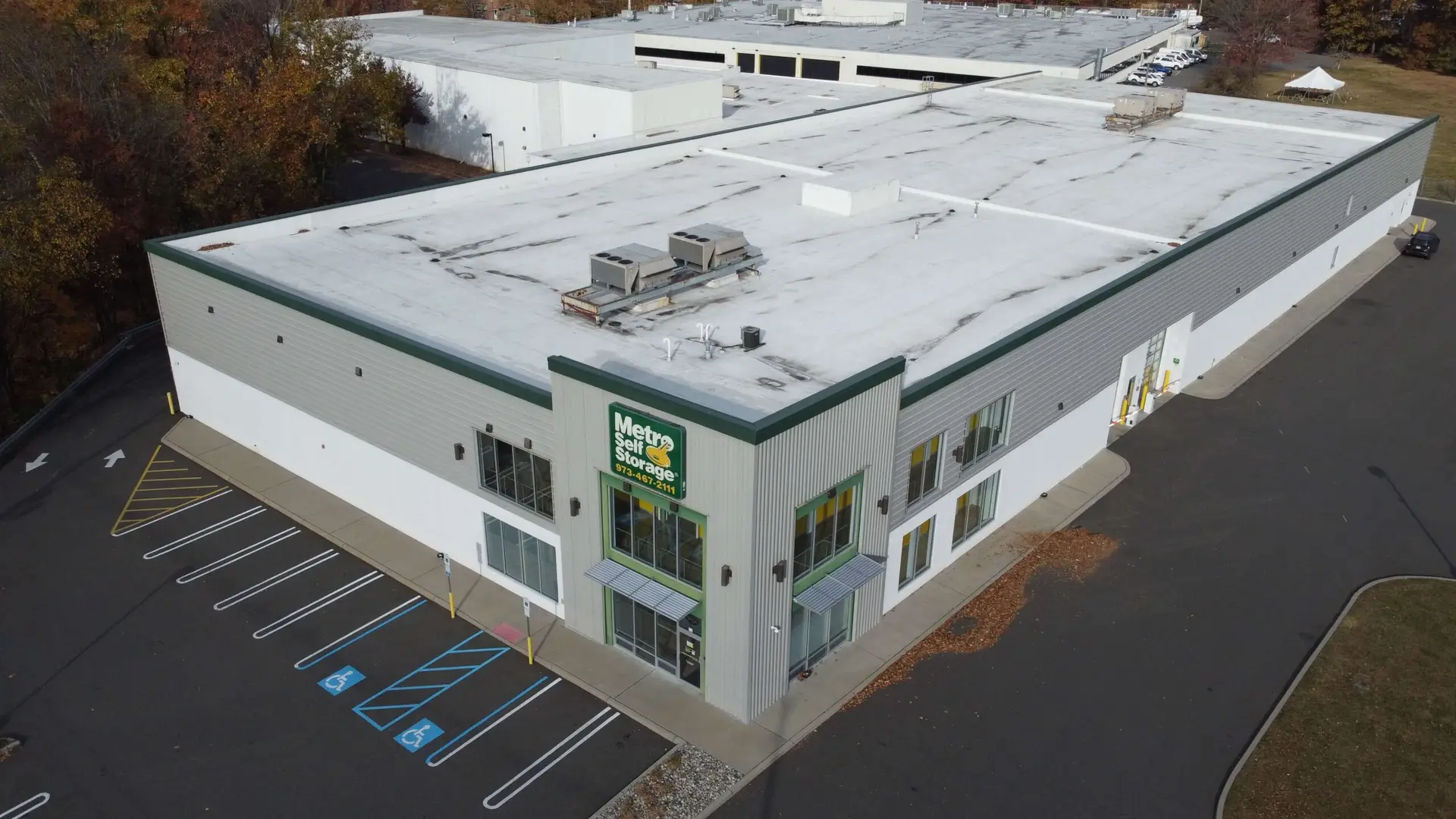 Aerial view of Metro Self Storage building in Springfield, NJ, featuring a white roof, green trim, and accessible parking spaces in front