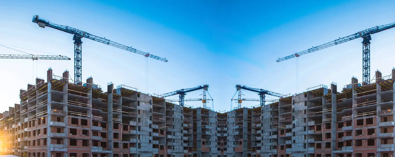 High-rise apartment buildings under construction showing active cranes and structural progress